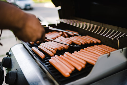 Man grilling sausages on barbeque grill