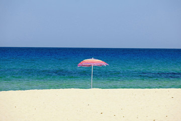 Sardinien Gestreifter Sonnenschirm am Strand der Cala Sinzias 