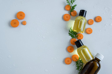 Top view of bottles with carrot essential oil. Healthy cosmetic product.