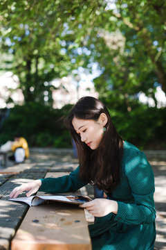 Young woman reading magazine in park
