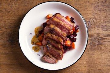 Duck breast with lavender, beetroot, sweet potato and maple syrup. View from above, top studio shot