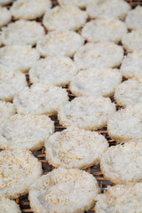 Close-up of sticky rice pressed into round flat cakes drying in the sun on a handmade bamboo tray in Luang Prabang, Laos.