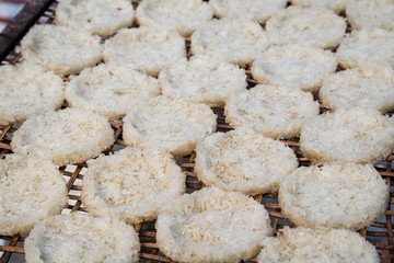 Close-up of sticky rice pressed into round flat cakes drying in the sun on a handmade bamboo tray in Luang Prabang, Laos.