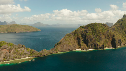 Fototapeta na wymiar Bay and the tropical islands. Seascape with tropical rocky islands, ocean blue wate, aerial view. islands and mountains covered with tropical forest. El nido, Philippines, Palawan. Tropical Mountain