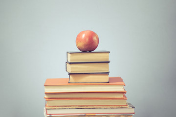 Book stack and apple on blue  education background,  back to school concept