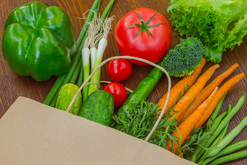Healthy food in full paper bag of different products, vegetables. Top view. Food background.