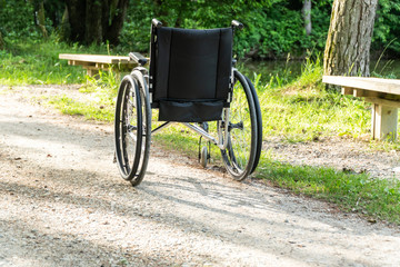 Empty wheelchair parked in park, health care concept