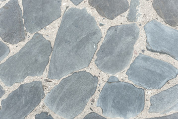Background of gray stone surface texture. Old road made of natural stone. Top view, horizontal, space of space close up.