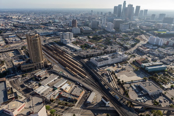 Aerial view of streets, buildings, transit train tracks, towers and homes in downtown Los Angeles...