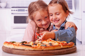 Cute little child girls best friends eating pizza.