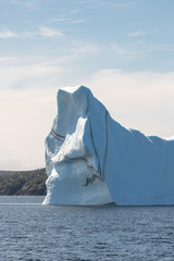 Huge iceberg with a stripe layer of sediment. Off the coast of Twillingate Newfoundland, Iceberg Alley.  