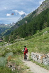 Fototapeta na wymiar active senior woman, riding her electric mountainbike below the famous Matterhorn in Zermatt, Wallis,Switzerland