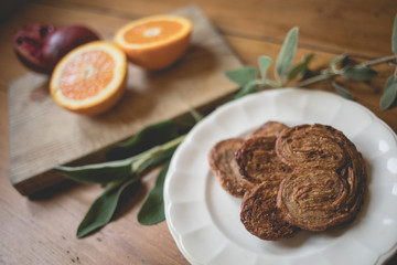 Breakfast time, table ready with sweets, orange and pomegranate. Morning and healthy lifestyle concept