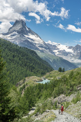 active senior woman, riding her electric mountainbike below the famous Matterhorn in Zermatt, Wallis,Switzerland