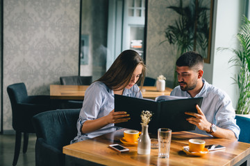 A happy young couple looking at their menu's at a restaurant