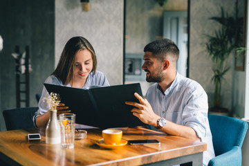A happy young couple looking at their menu's at a restaurant