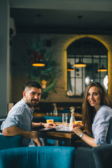 happy young couple posing in restaurant