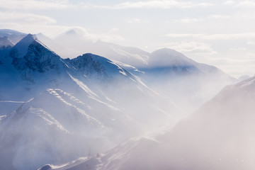 Daylight view of austrian mountains. Haze and sun