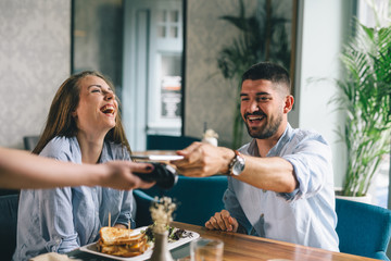 man making payment with smartphone in restaurant
