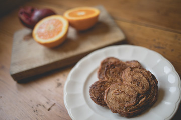 Breakfast time, table ready with sweets, orange and pomegranate. Morning and healthy lifestyle concept
