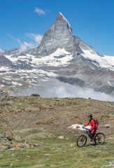 Fototapeta premium active senior woman, riding her electric mountainbike below the famous Matterhorn in Zermatt, Wallis,Switzerland