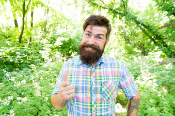 Naklejka na ściany i meble Man handsome beard and mustache in summer forest. United with environment. Summer vacation concept. Explore wild nature activity. Man bearded hipster green trees background. Emotional nature lover