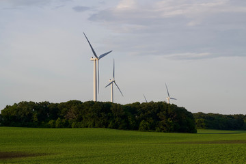 Obraz premium Giant wind turbines in a rural agricultural setting