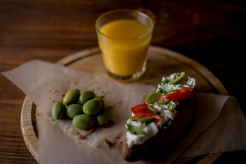 Bruschetta with cheese and olives on a wooden table