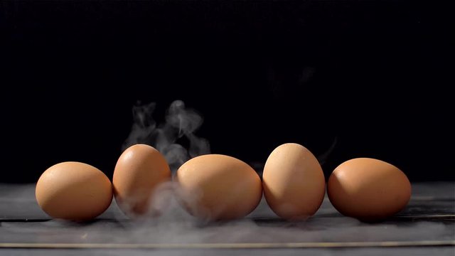 Smoker in slow motion on black background and eggs