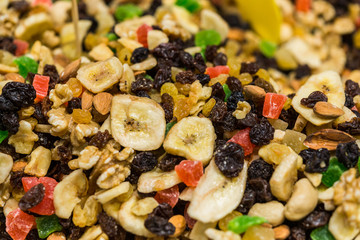Close up of dried fruit and nuts mix with banana, raisins, almonds, walnuts, and candied fruit