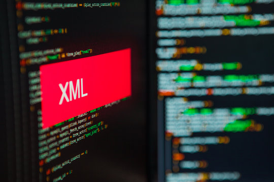 Programming language, XML inscription on the background of computer code.