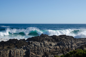 The waves breaking on a stony beach, forming a spray, africa