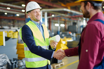 Engineer and foreman shake hands after successfully discussing a new project.