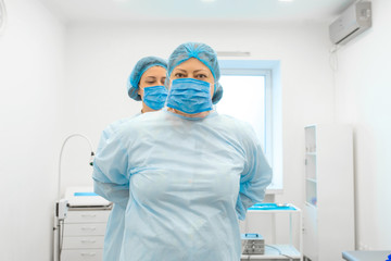 a nurse puts a surgeon in a sterile suit before surgery