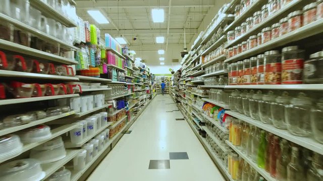 At the supermarket store pov action camera motion, through row section of the shop and different items merchandise. Front view shot. 4k.