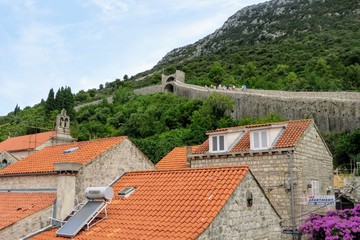 Looking upwards from the old croatian town of Ston at the ancient Walls of Ston in the forested...