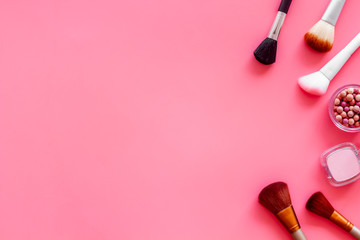 Brushes for make up, blusher on pink visagiste work desk background top view copyspace