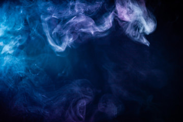 Abstract colorful smoke on black background .