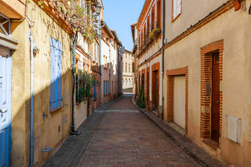 Fototapeta na wymiar Street in French ancient town Toulouse. Toulouse is the capital of Haute Garonne department and Occitanie region, France, South Europe. Famous tourist destionation.