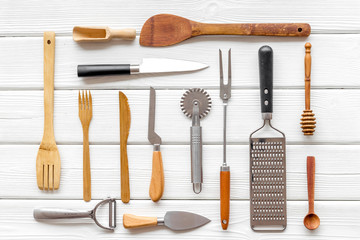 Pattern of cookware for chef work on white wooden background top view