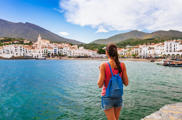 Tourist woman in Cadaques, Catalonia, Spain near of Barcelona. Scenic old town with nice beach and clear blue water in bay. Famous resort destination in Costa Brava with Salvador Dali landmark