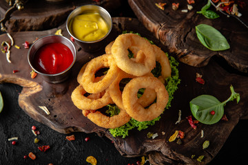 Delicious crunchy snack: chicken nuggets, french fries and breaded onion rings