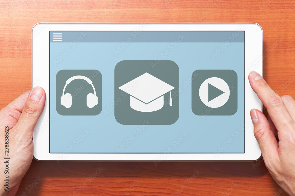 Poster E-learning concept image. Closeup of hands touching white tablet computer on wooden desk. Application on screen. Front view image.