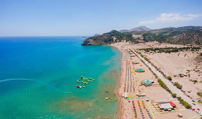 Aerial birds eye view drone photo Tsambika beach near Kolympia on Rhodes island, Dodecanese, Greece. Sunny panorama with sand beach and clear blue water. Famous tourist destination in South Europe