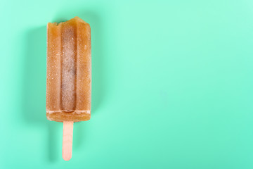 red bean popsicle with some bites on light green background