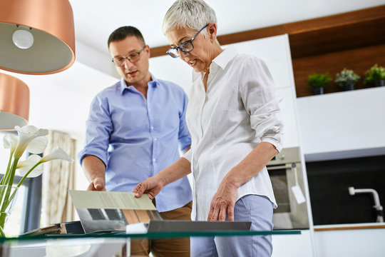 Man and mature woman in a kitchen retail store examining material samples