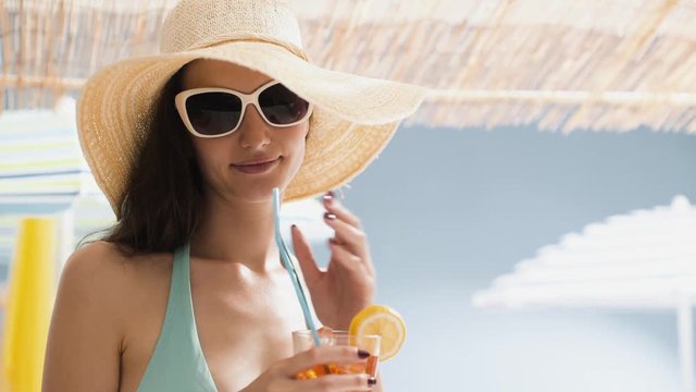 Beautiful girl having a drink at the beach bar kiosk
