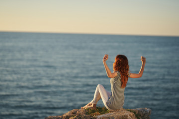 young woman doing yoga on the beach