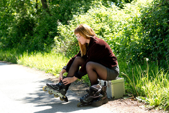 Young woman putting on inline skates