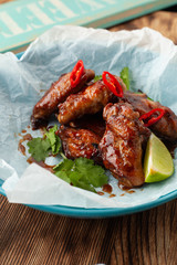 Close up of jamaican style glazed chicken wings with chili pepper and teriyaki sauce